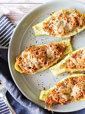 cheesy roasted squash boats on a gray plate