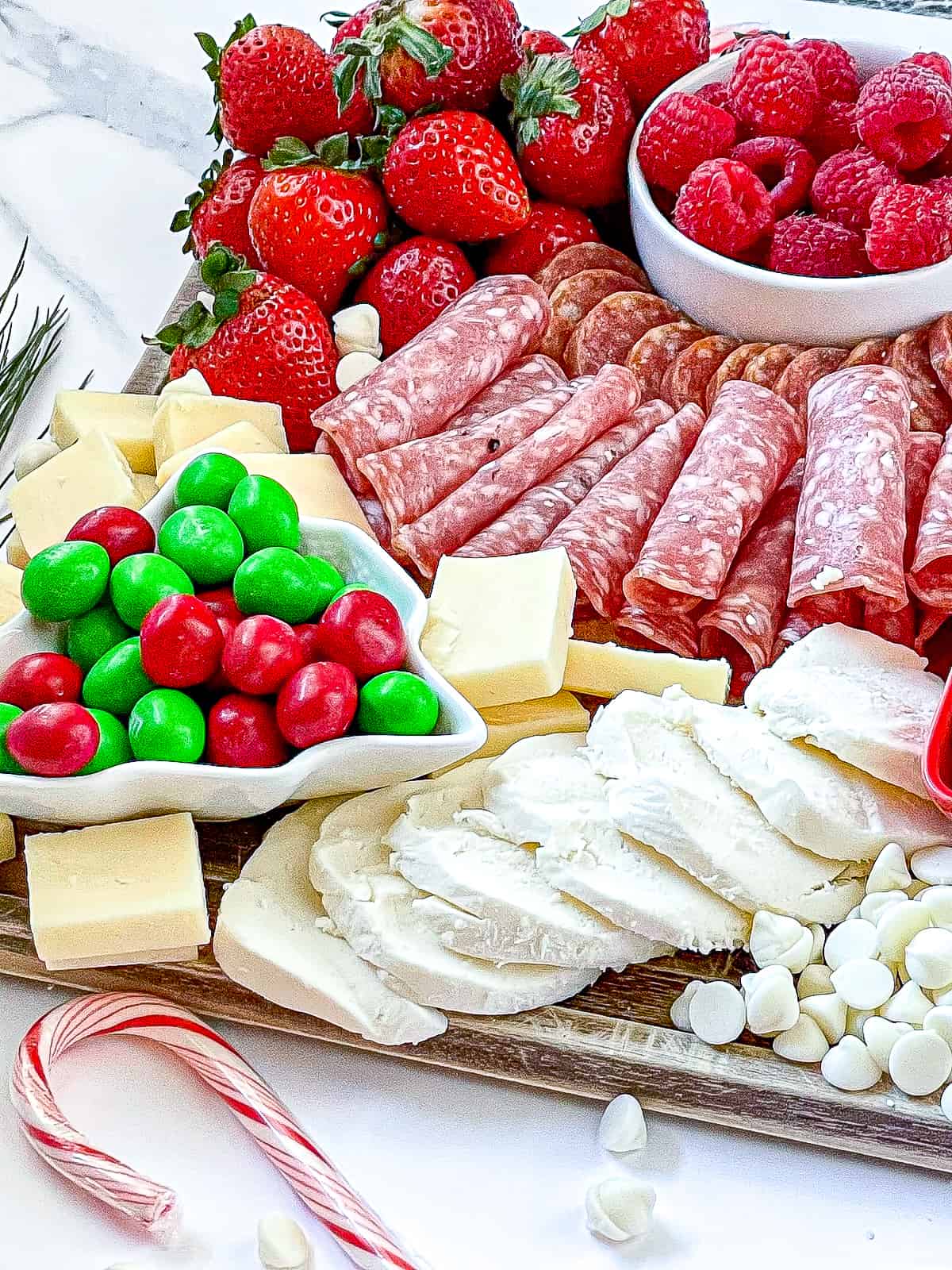 Christmas charcuterie board with red fruit and meat and white cheese