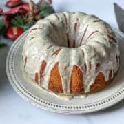 eggnog cake on a white plate, glazed with icing and sprinkled with nutmeg