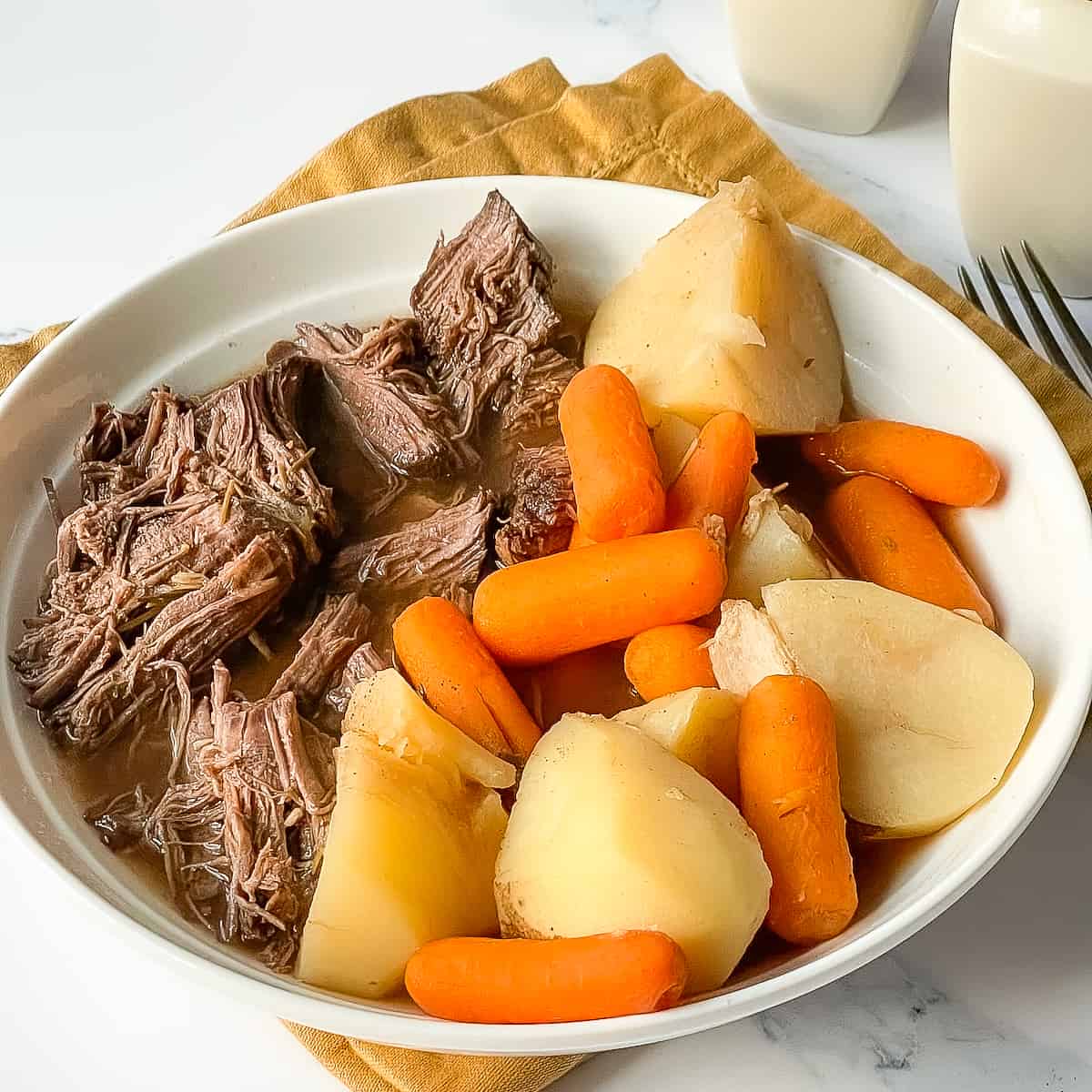 Instant Pot Venison Roast with potatoes and carrots in a white bowl