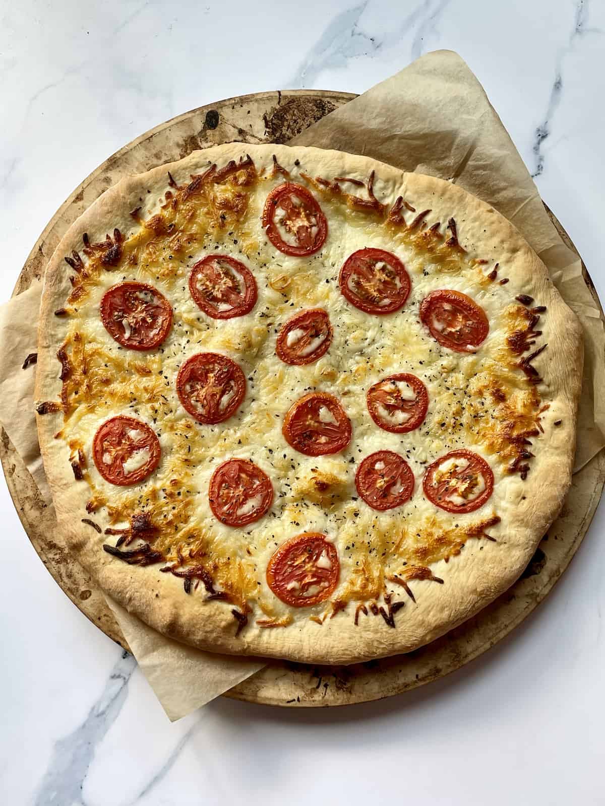 cooked white pizza on a pizza stone with a white background