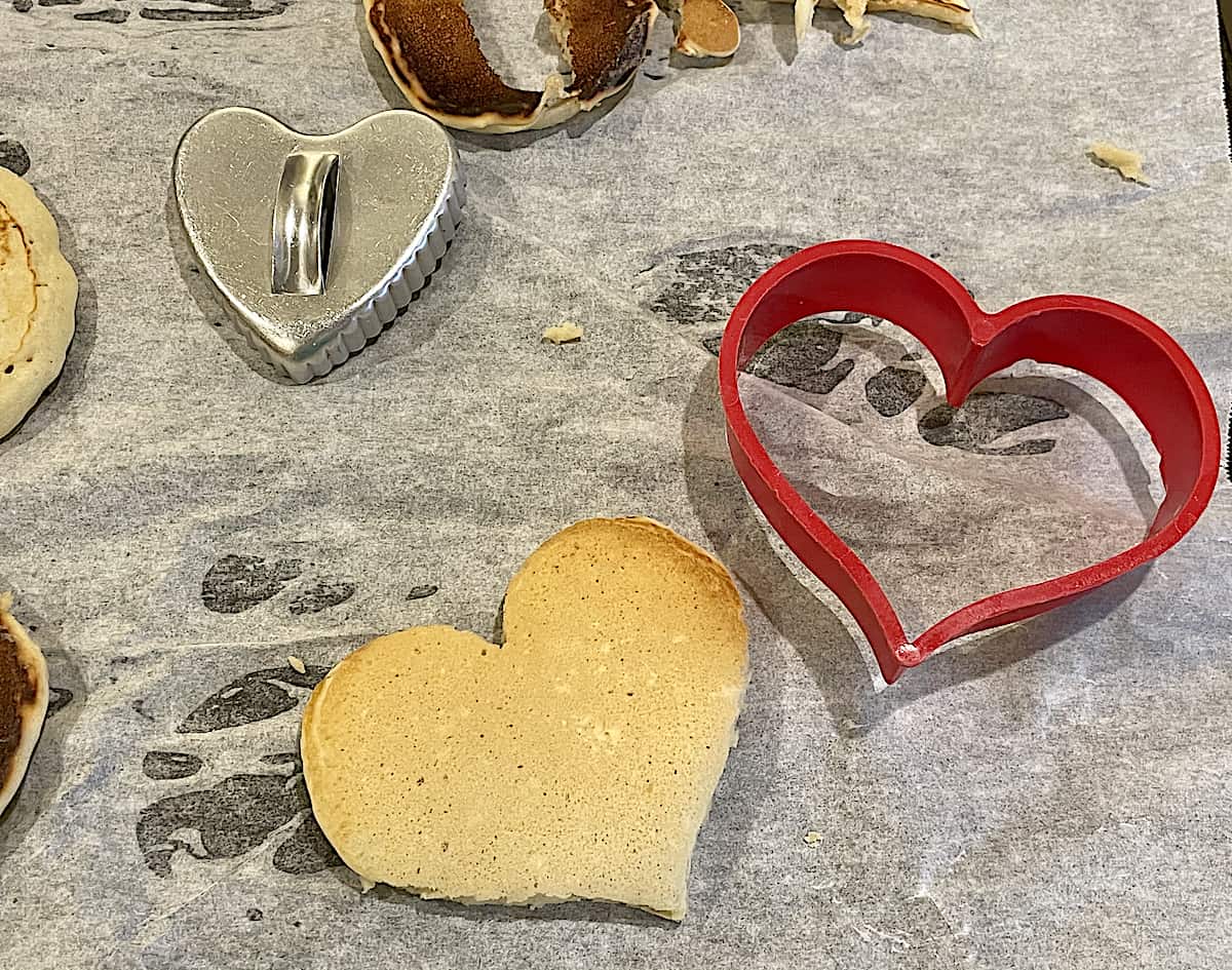 heart cookie cutters on parchment paper, cutting pancakes