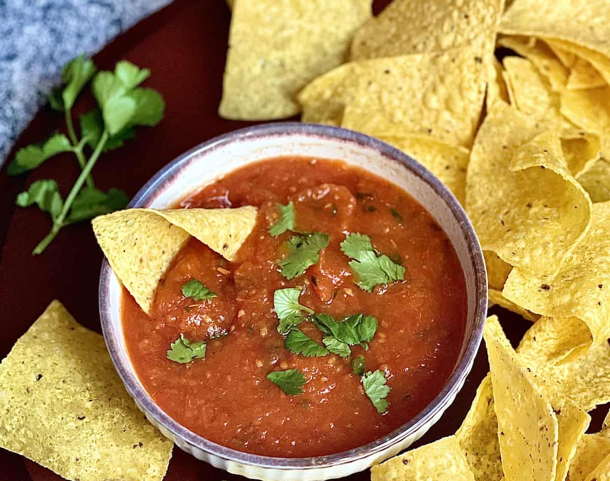 Instant pot salsa in a large bowl and surrounded by chips