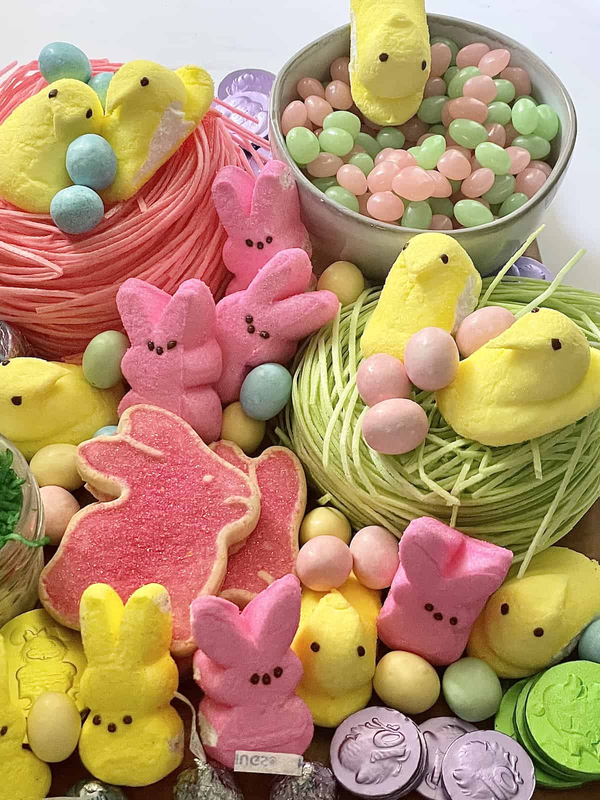 birds nest, peeps, cookies, and candies on a charcuterie board