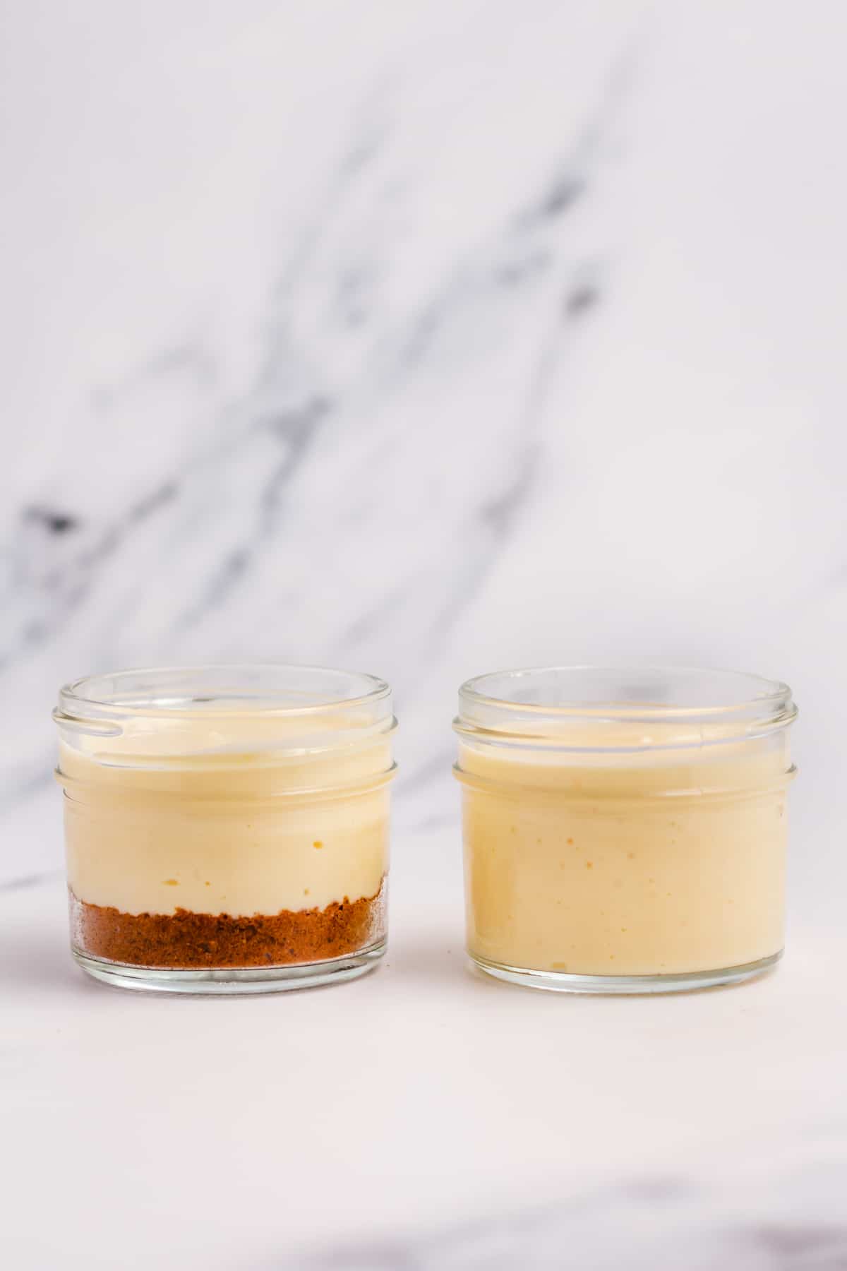 cheesecake filling and crust uncooked in a mini mason jar