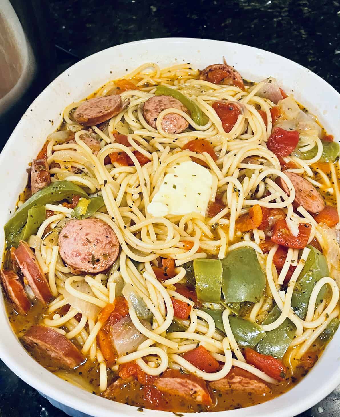 kielbasa pasta topped with butter in a serving dish