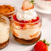 instant pot mini cheesecake with strawberry and whipped cream topping in a mini mason jar