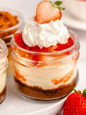 instant pot mini cheesecake with strawberry and whipped cream topping in a mini mason jar