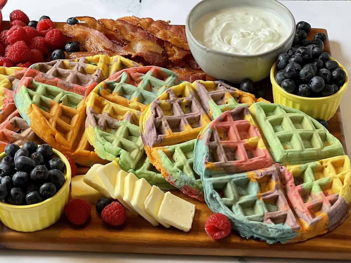 close up of rainbow waffles on a charcuterie board