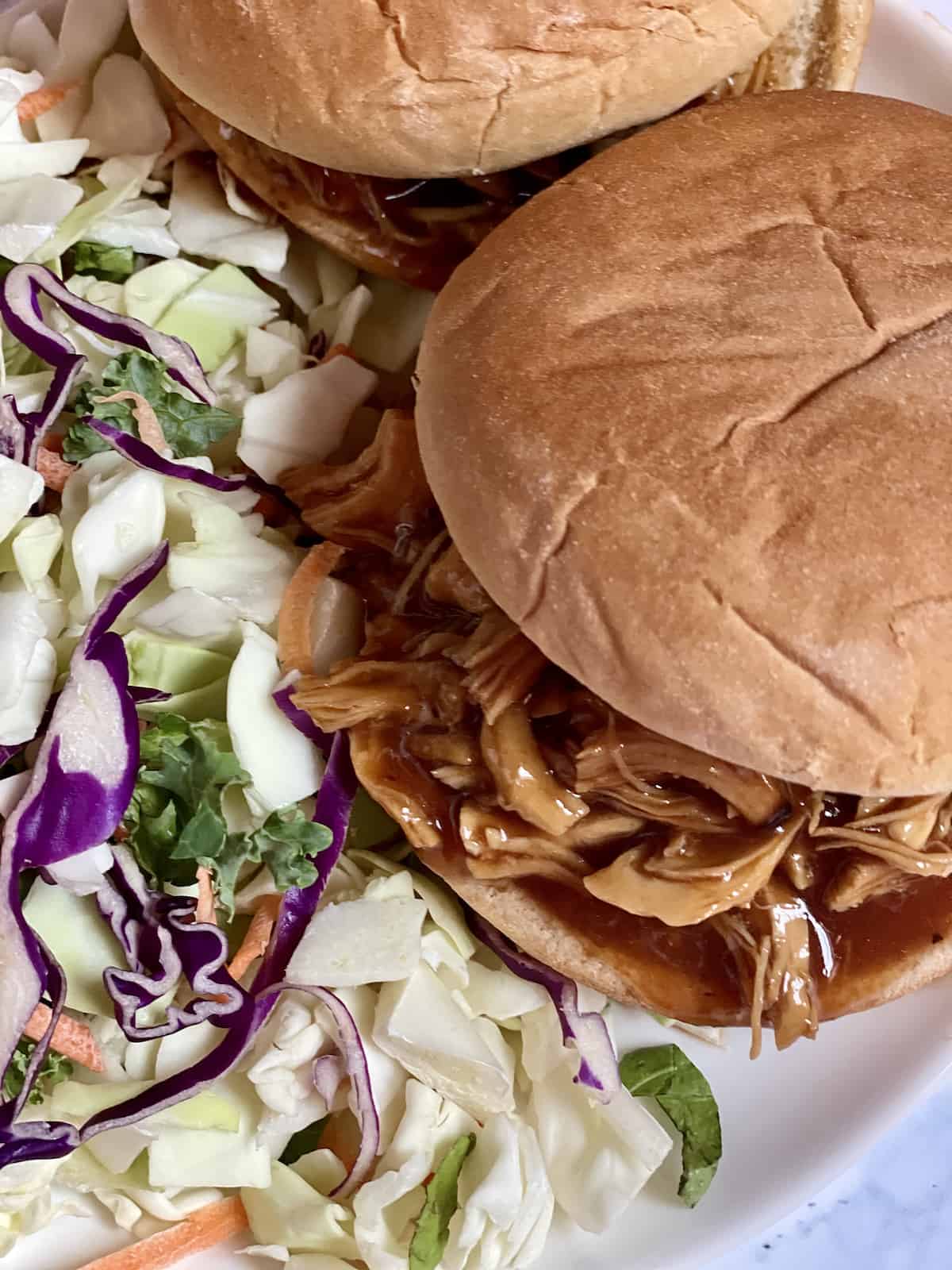 pulled barbecue chicken on a sandwich roll served with coleslaw