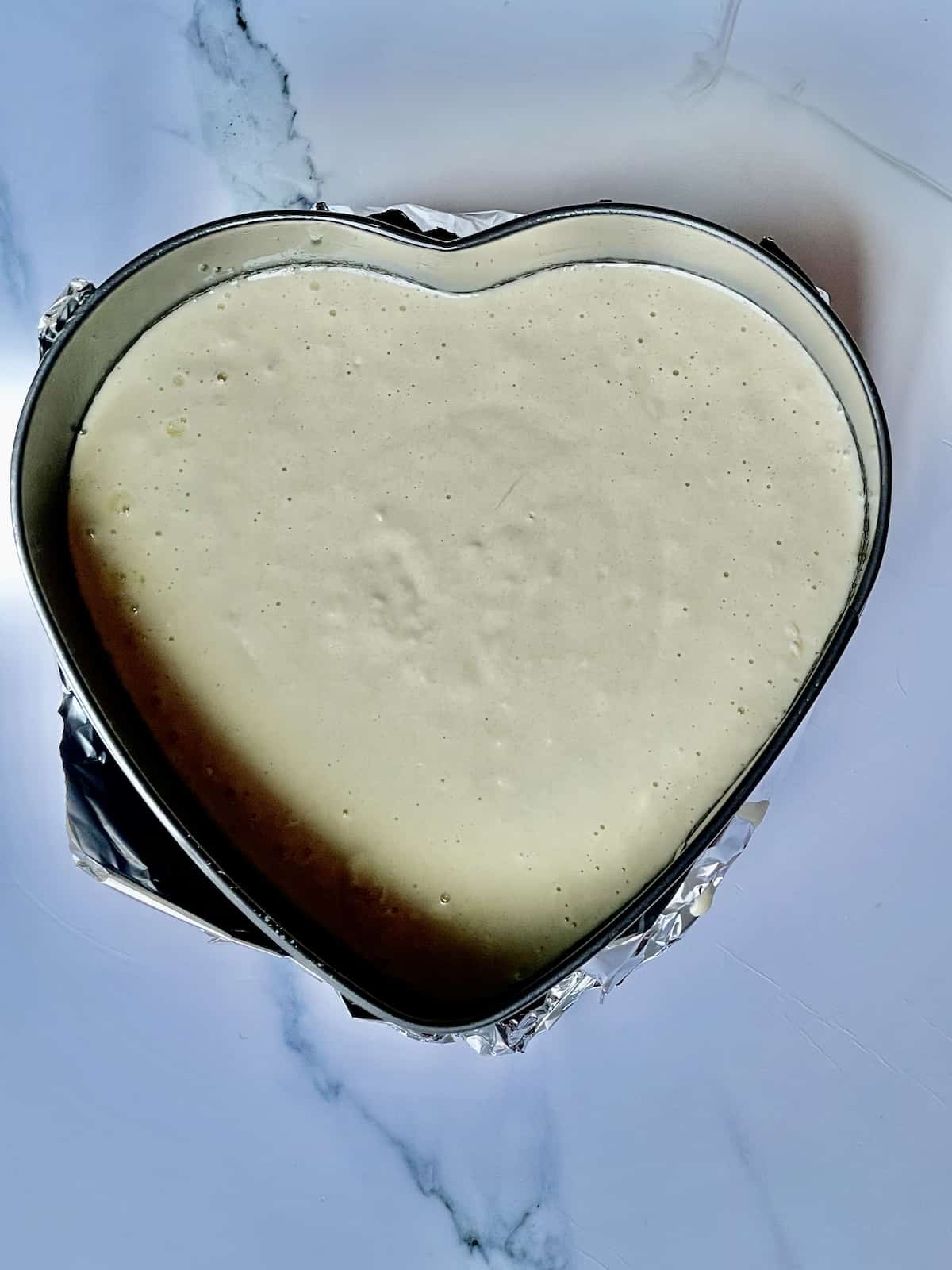 pancake batter in a heart shaped spring form pan