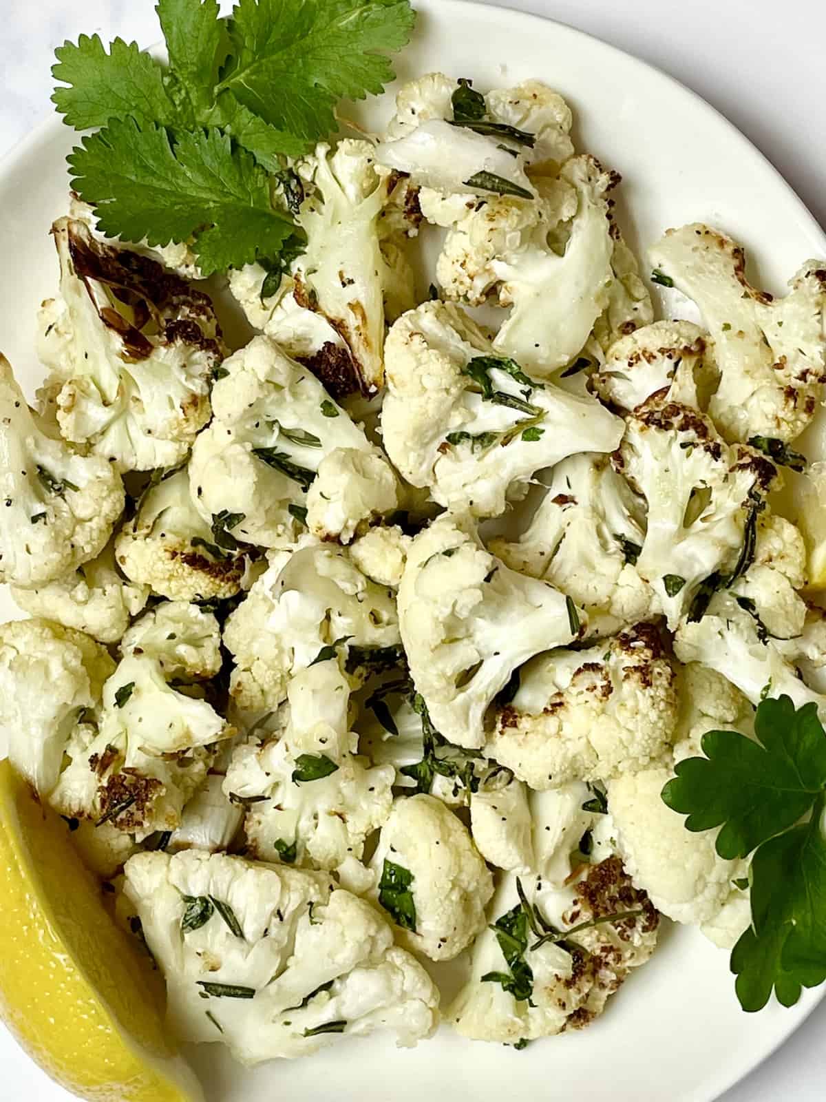 air fried cauliflower with lemon and herbs in a white bowl