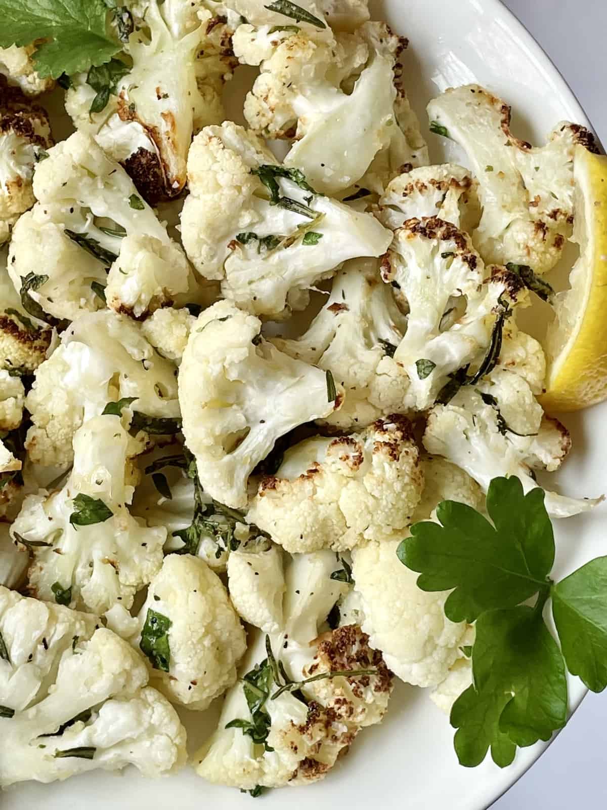 air fried cauliflower with lemon and herbs in a white bowl