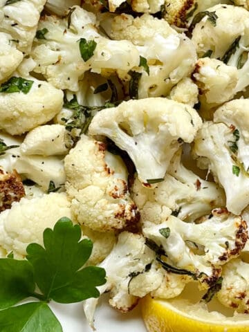 air fryer cauliflower with herbs and lemon on a plate