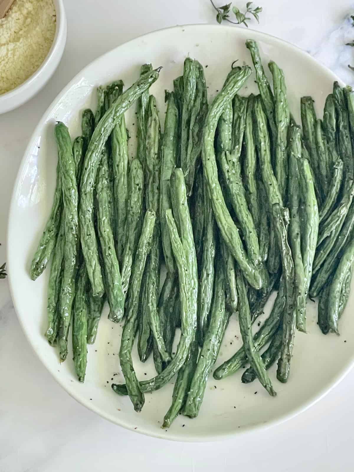 green beans on a white plate with salt and pepper