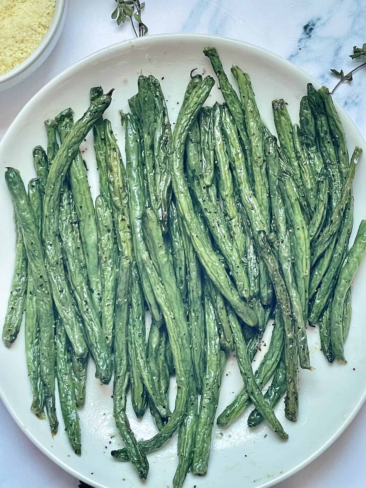 air fried green beans with salt and pepper on a white plate