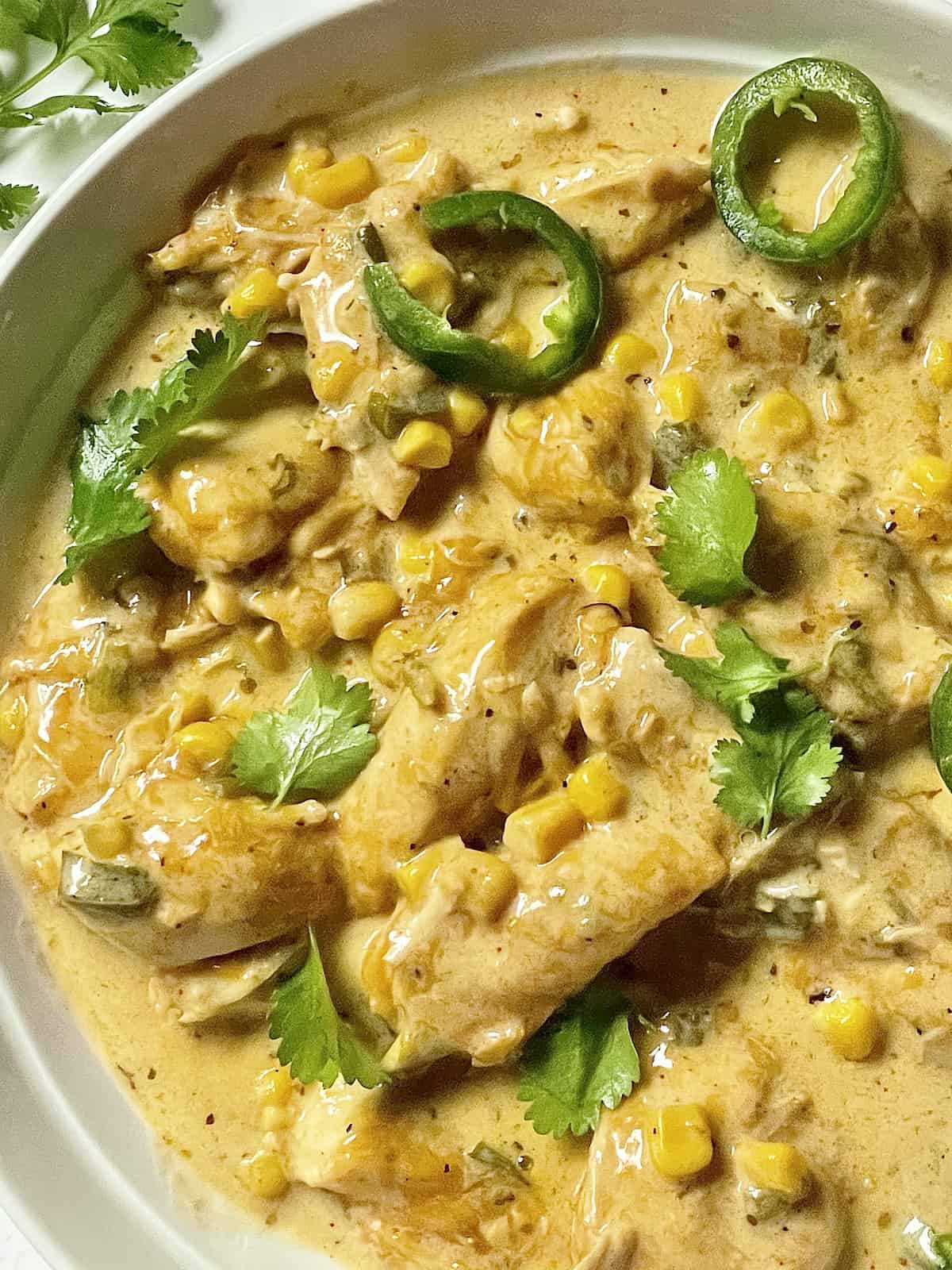 Instant pot creamy chicken topped with jalapenos and cilantro in a bowl