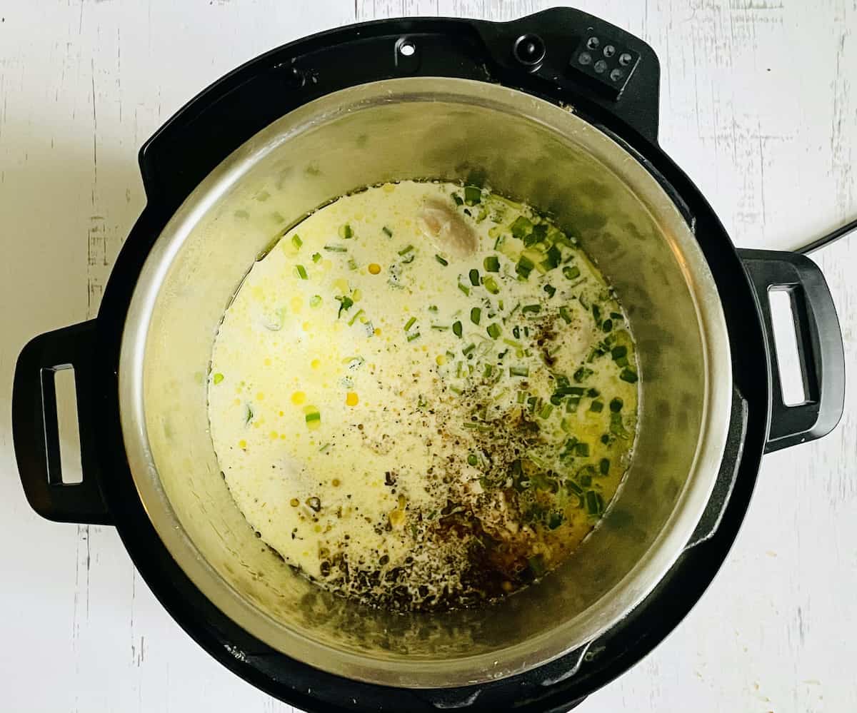 chicken, jalapenos, spices, corn, scallions, and milk in a pressure cooker
