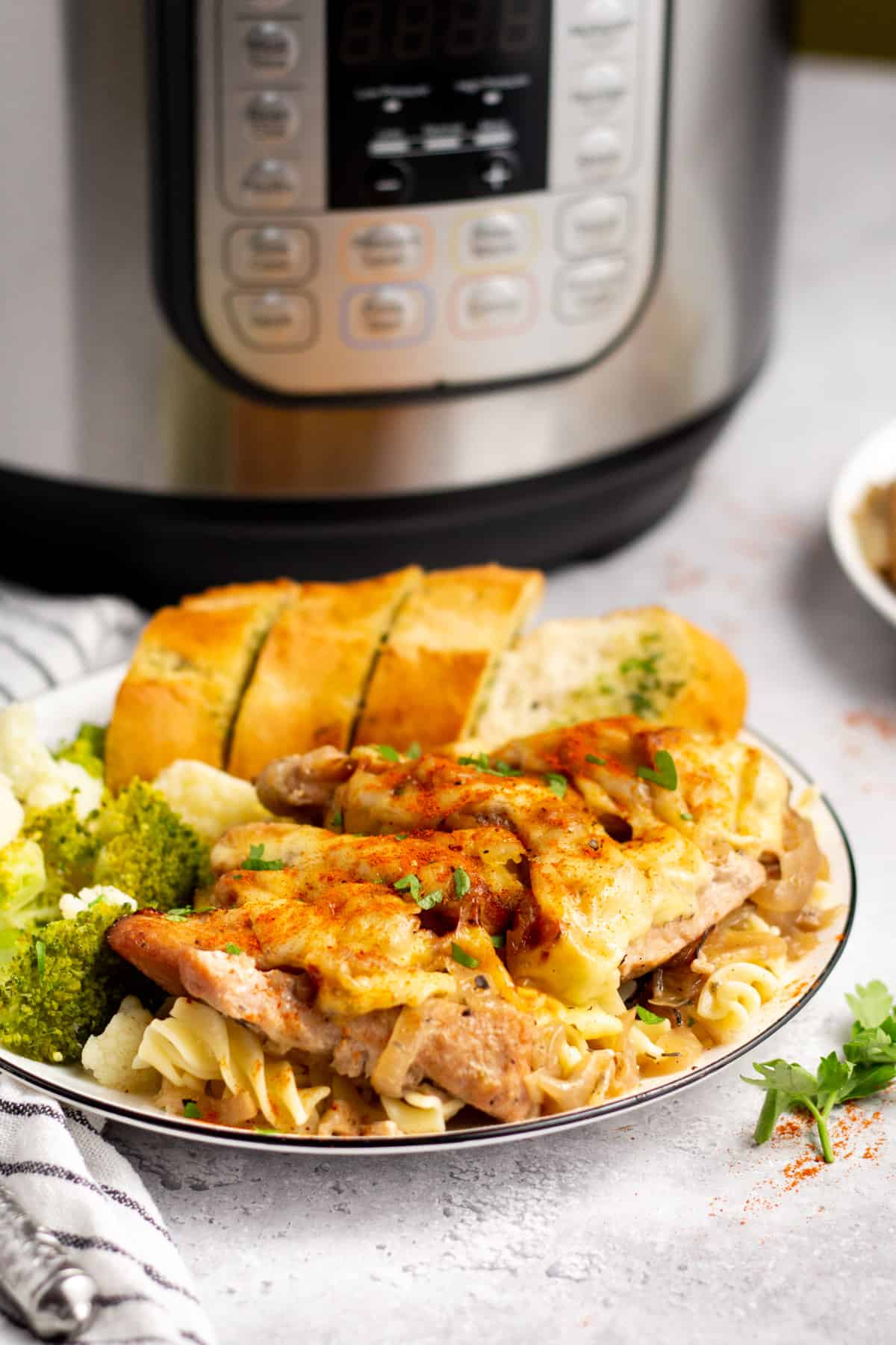 instant pot french onion chicken on a plate with vegetables and bread