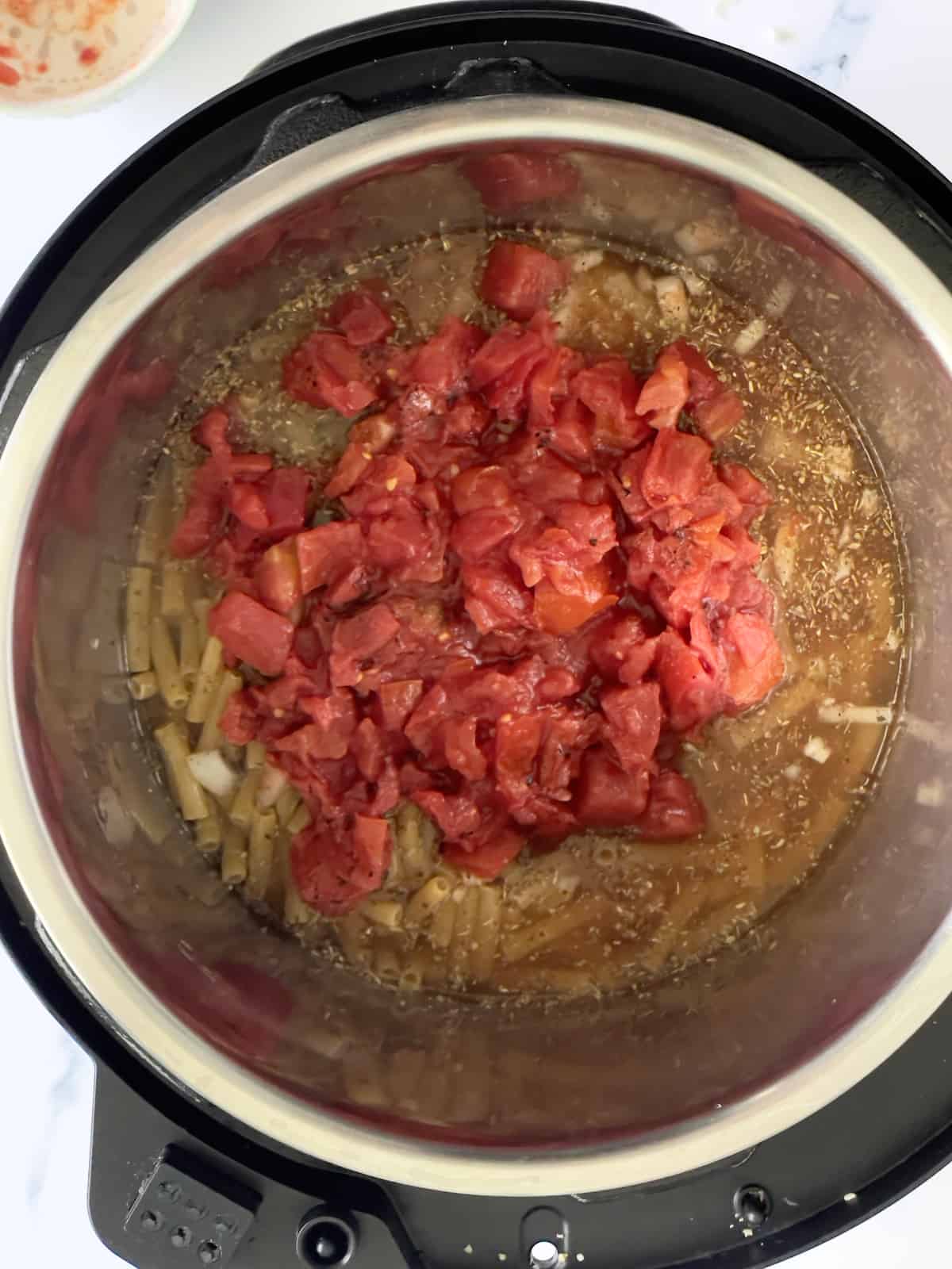 fire roasted tomatoes added on top of pasta in the inner pot