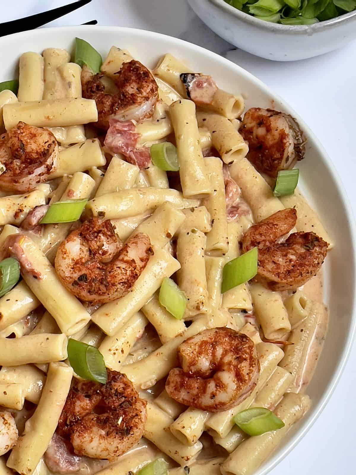 cajun shrimp on top of creamy cajun pasta in a bowl