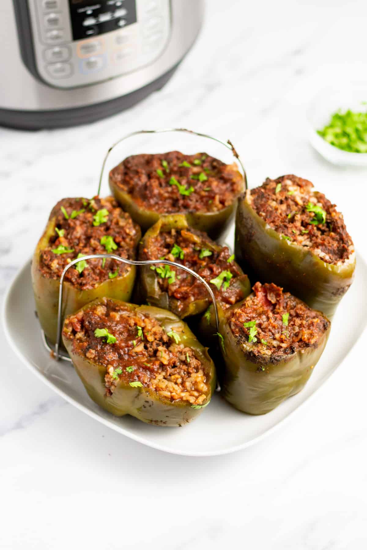 stuffed peppers on a trivet on a large plate