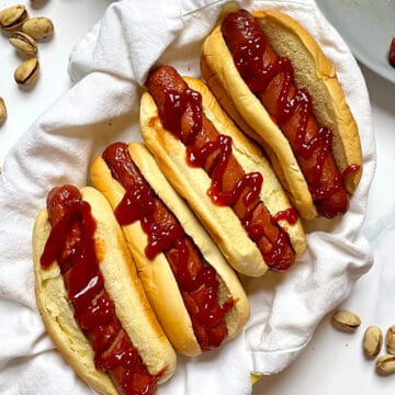 air fryer hot dogs in buns with ketchup in a basket
