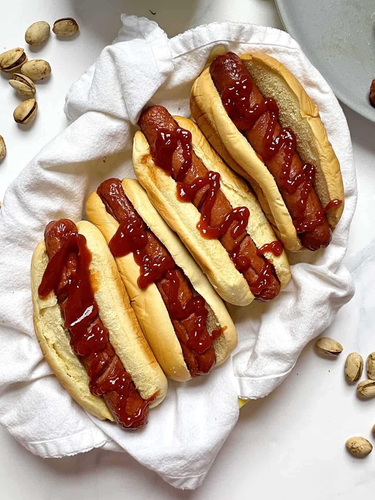 air fryer hots in a basket with ketchup and pistachios