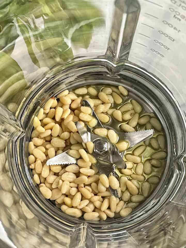 whole pine nuts with olive oil in a cooking blender