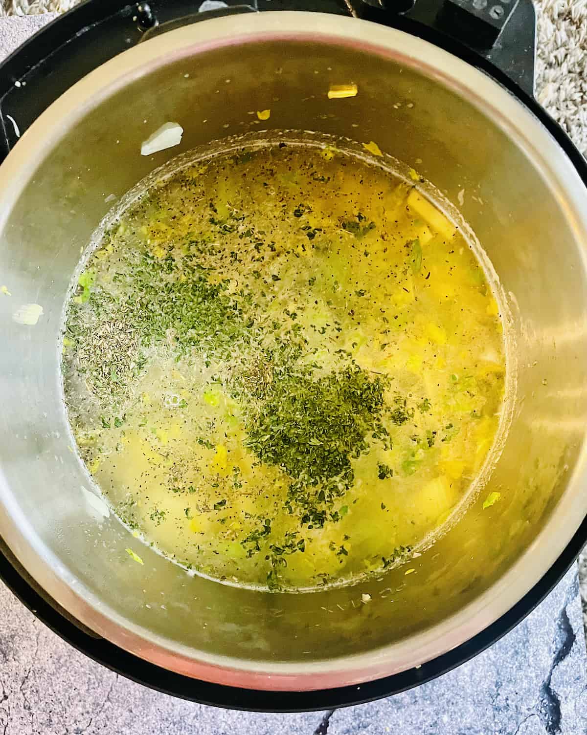 thyme, salt, pepper, broth, and potatoes in the pressure cooker