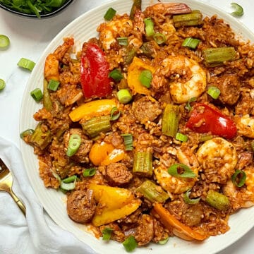 instant pot jambalaya with shrimp and sausage on a white plate topped with scallions