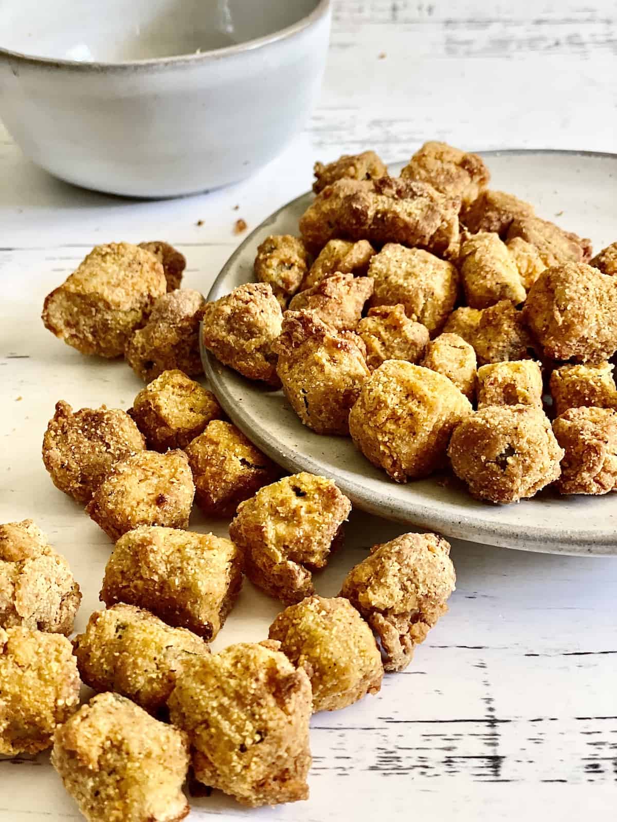 air fried okra on a white plate and spilling onto a white table