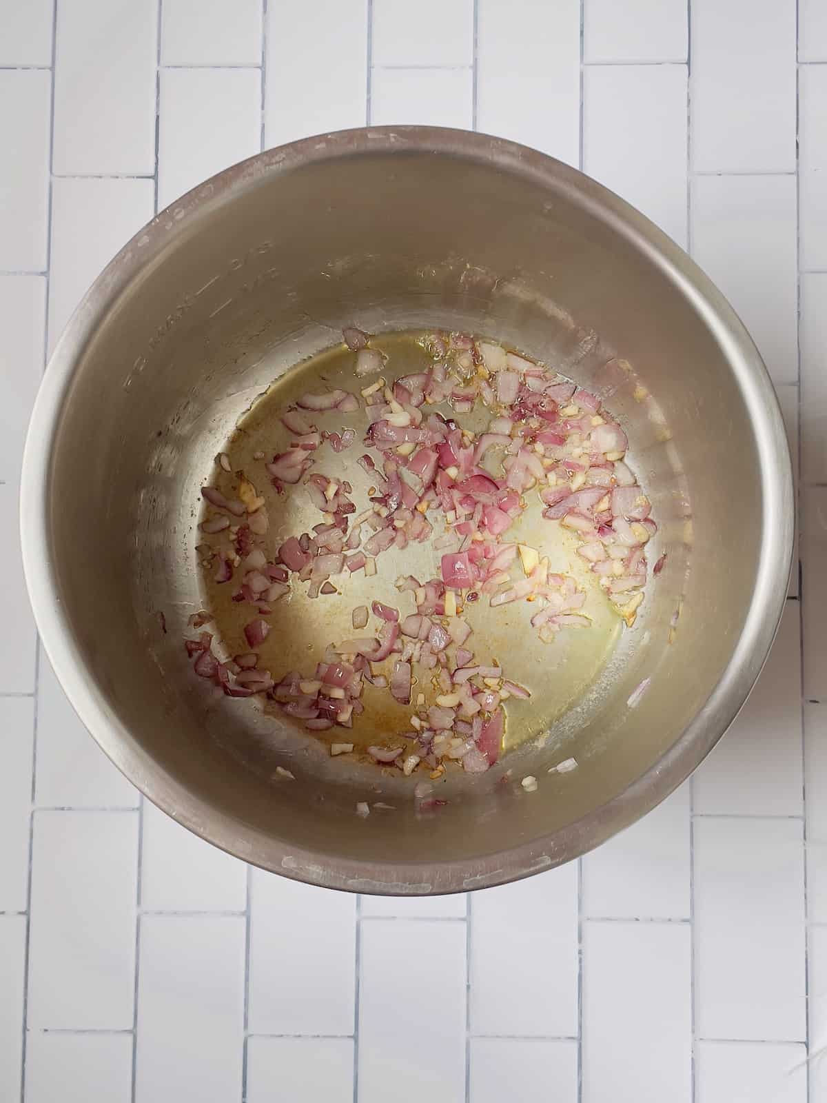 onions and garlic cooking in a pressure cooker