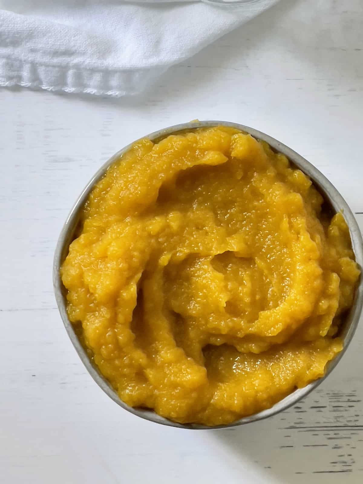 homemade pumpkin puree in a white bowl overhead picture