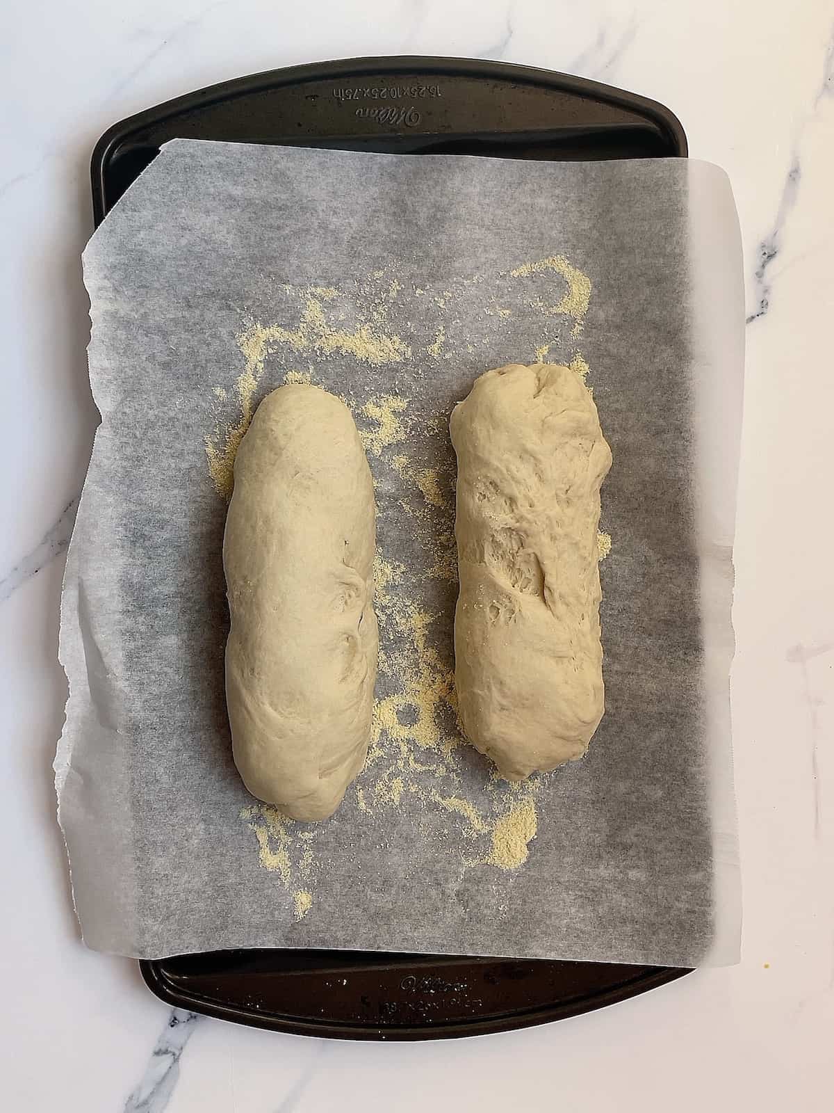 2 shaped loaves of bread on a baking sheet