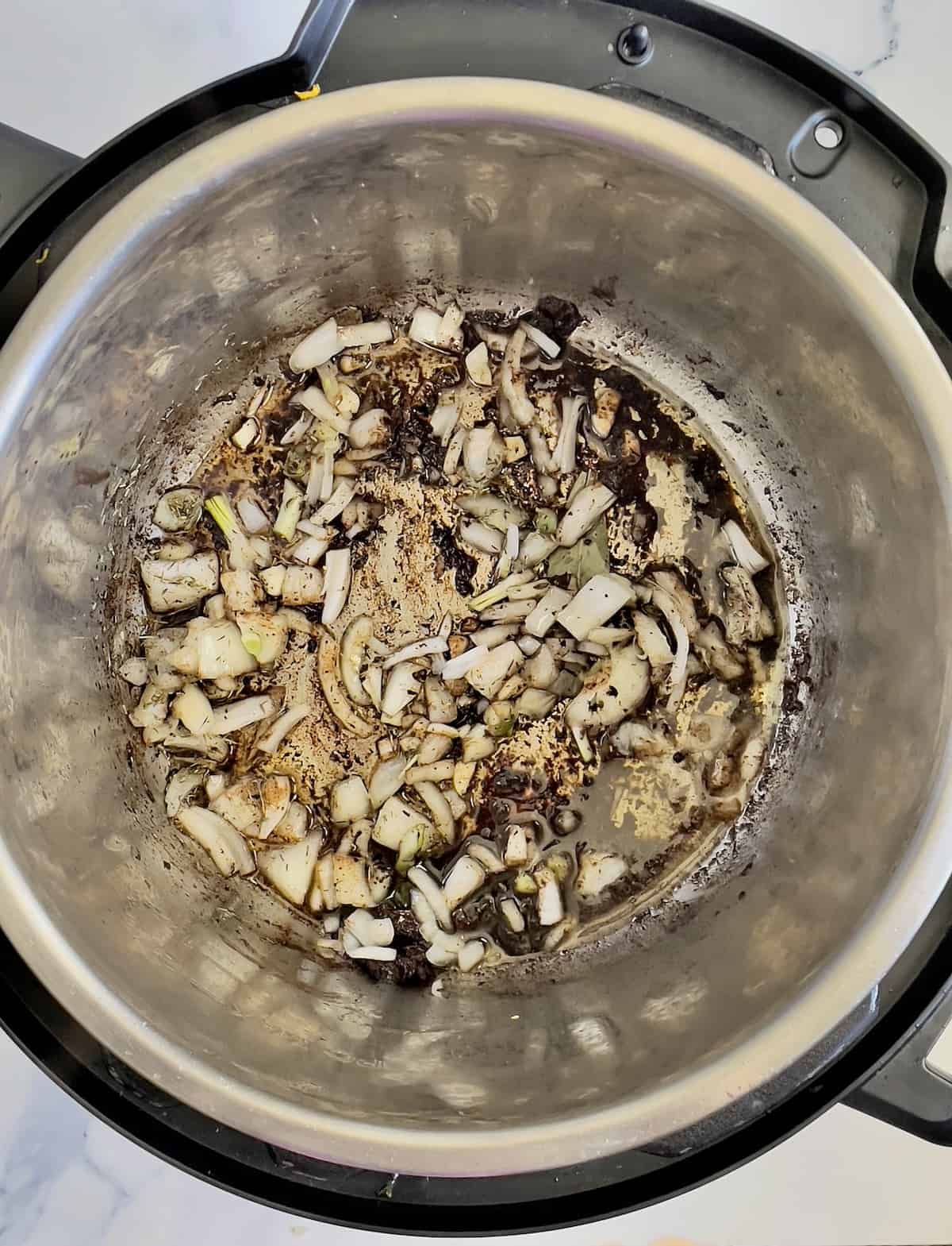 onions and garlic in an instant pot, cooking