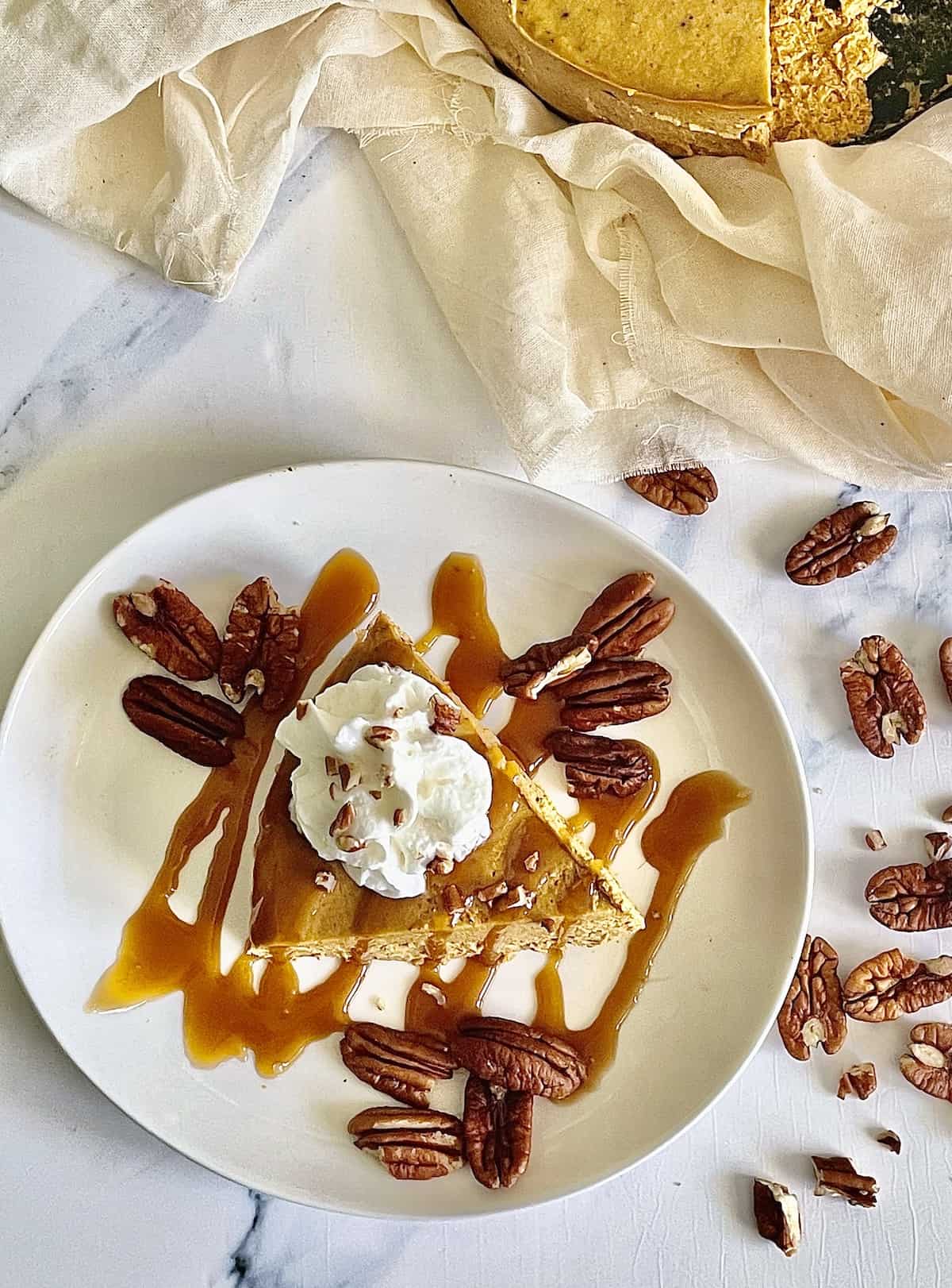 pumpkin cheesecake topped with caramel and whipped cream