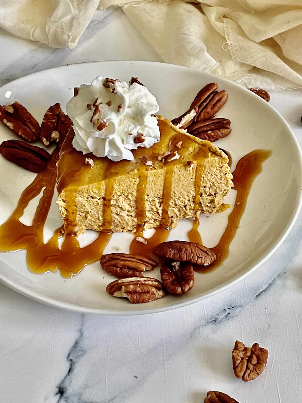 instant pot pumpkin cheesecake topped with caramel sauce and whipped cream