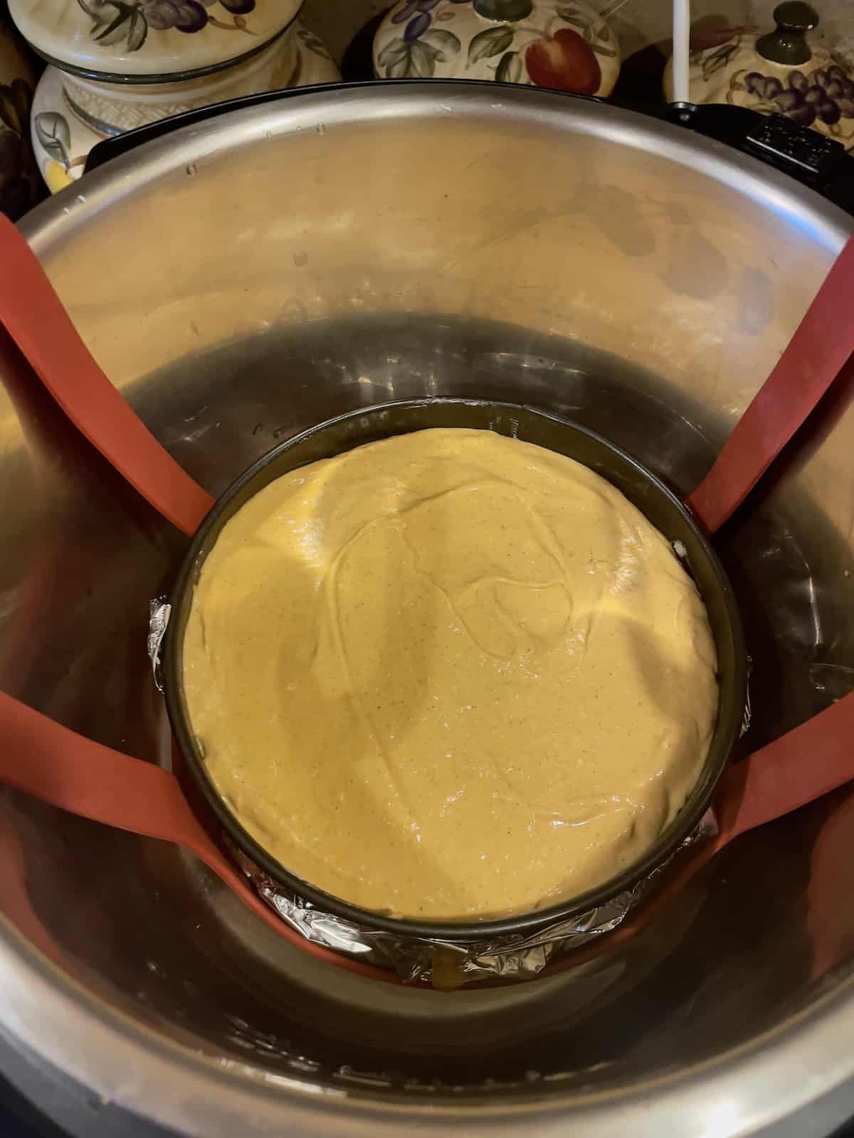 cheesecake poured into a pan inside the inner pot