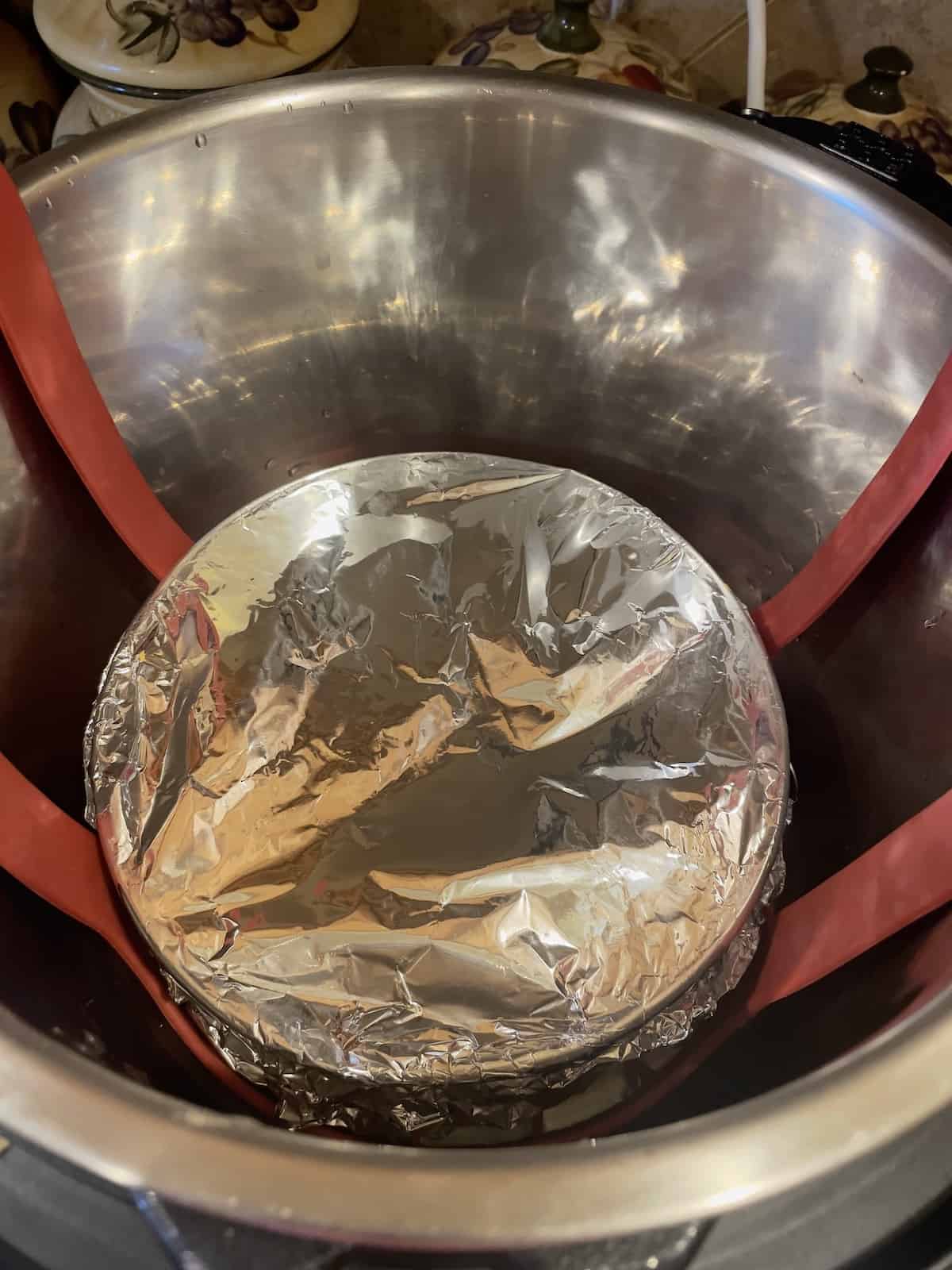 cheesecake covered with foil in a pressure cooker