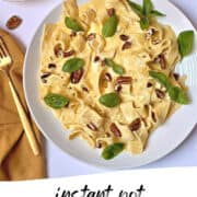 instant pot pumpkin pasta topped with basil and walnuts in a white plate