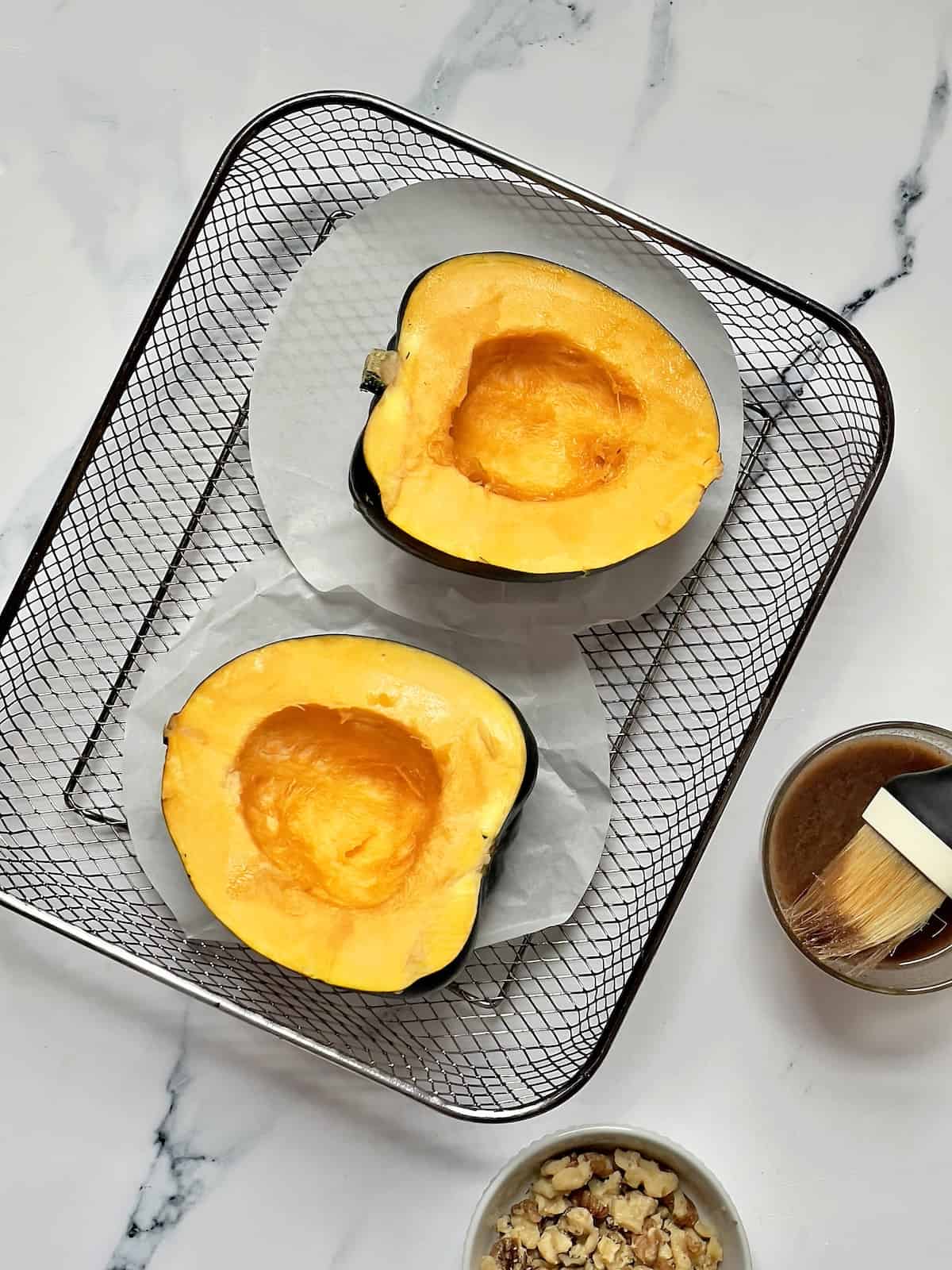 sliced acorn squash on an air fryer tray