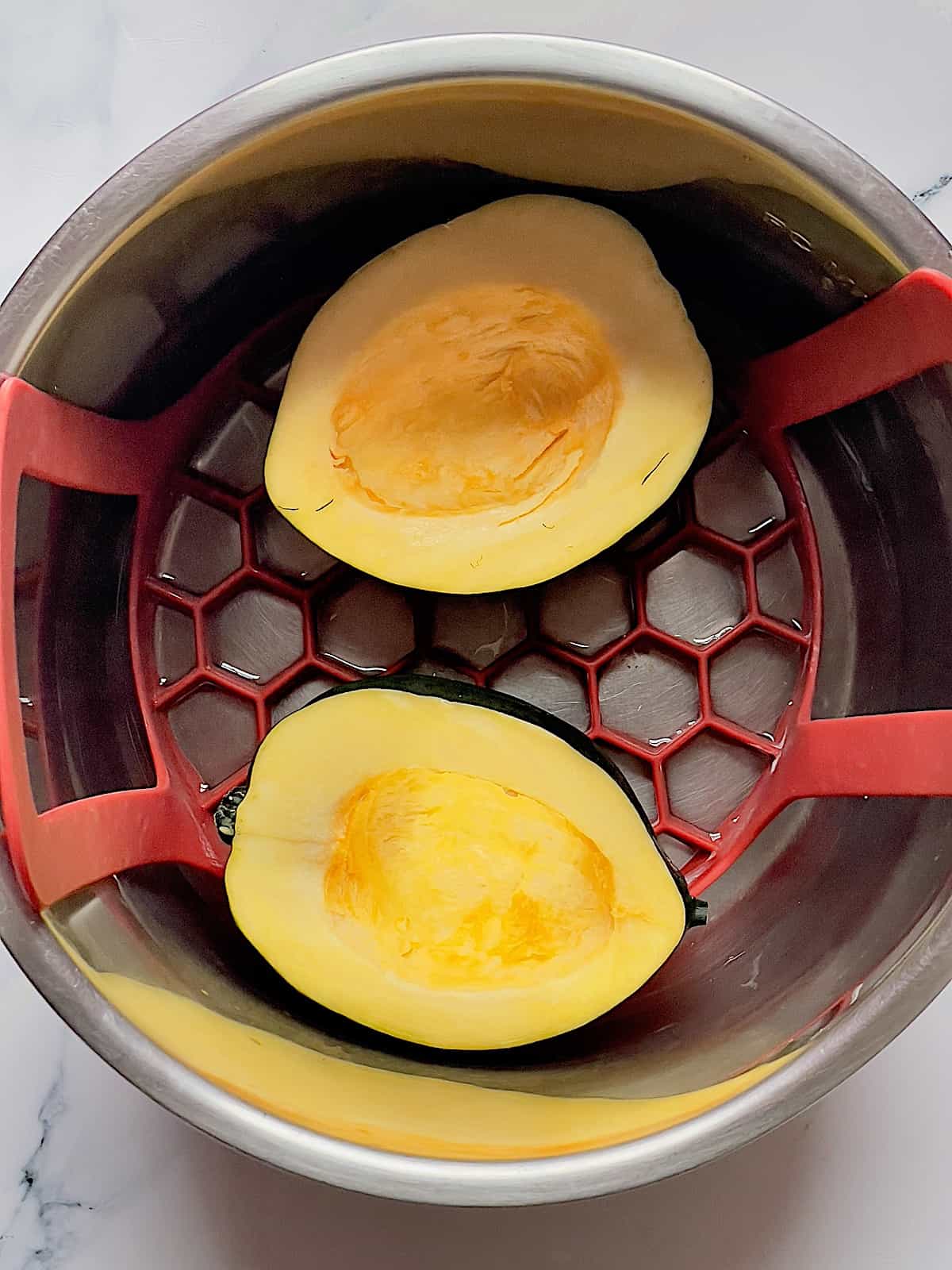 acorn squash halves on a trivet in the instant pot