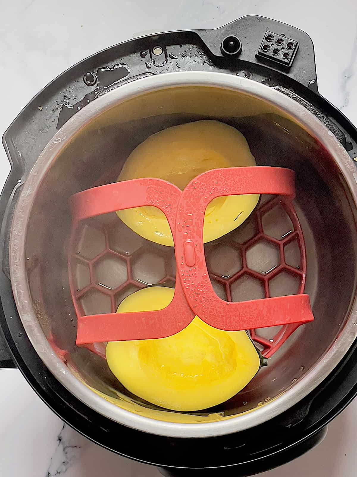 pressure cooked acorn squash in the inner pot on a silicone sling