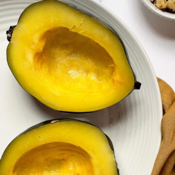 pressure cooked acorn squash sliced in half on a white plate