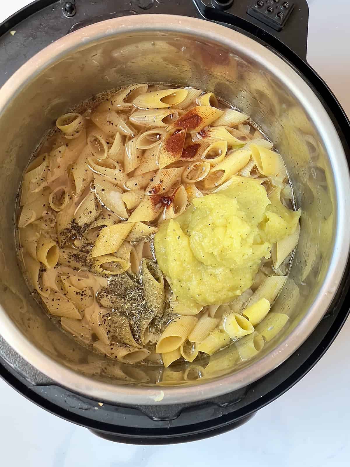 pasta, acorn squash puree, spices, and vegetables in a pressure cooker