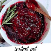 FRESH CRANBERRY SAUCE IN A WHITE BOWL WITH ROSEMARY SPRIGGS