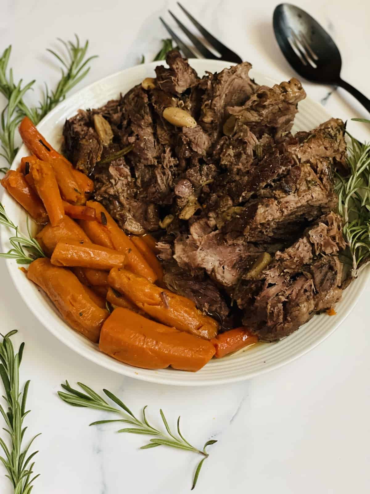 pressure cooked leg of lamb with carrots on a serving dish