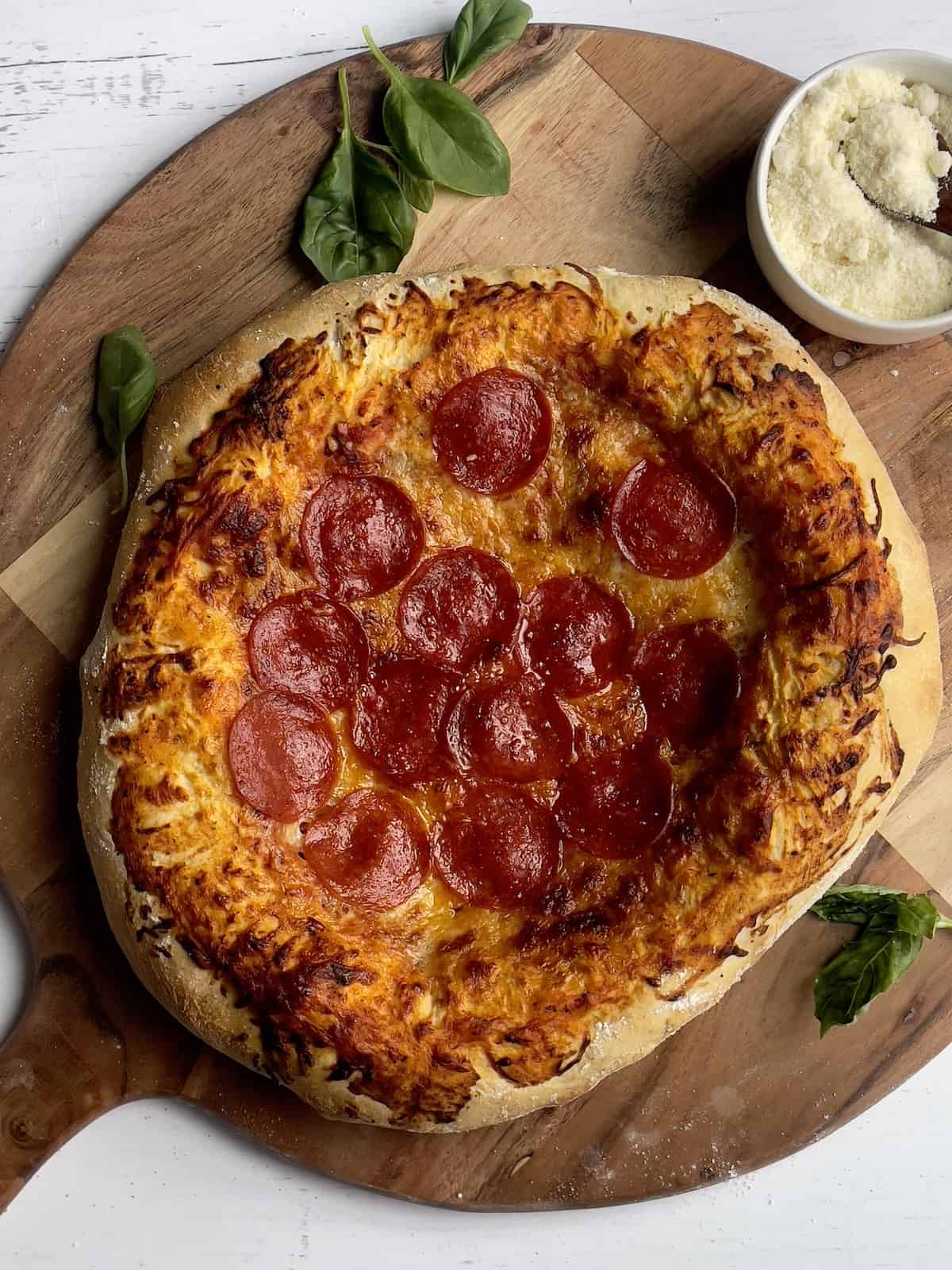 pepperoni pizza on a wooden pizza peel