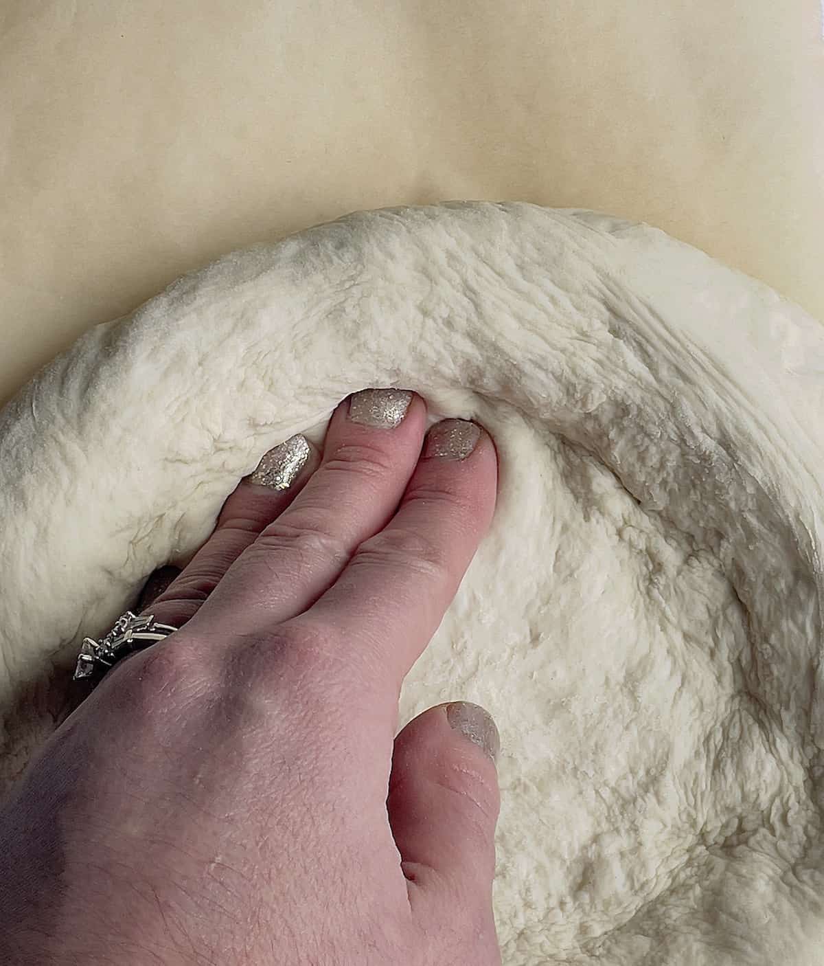 hands stretching dough into a circle